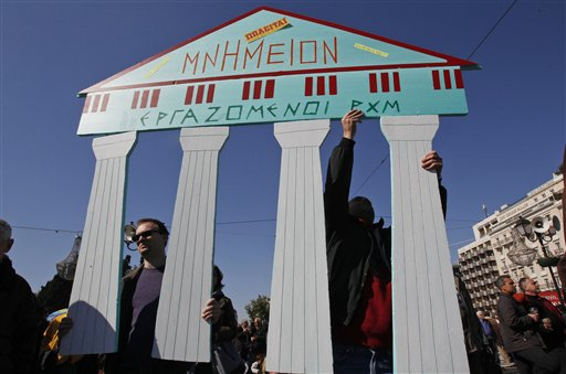 Employees of the Byzantine and Christianity museum hold a cardboard replica of ancient ruins which reads: ''Monument for sale'' during a peaceful protest outside the Greek Parliament in Athens, Sunday, Feb. 19, 2012 (AP Photo/Thanassis Stavrakis)
