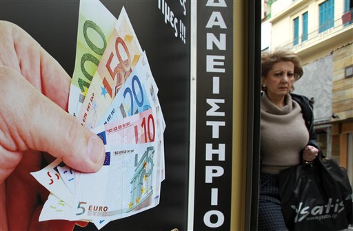 A pedestrian passes outside a pawnshop in Athens, Tuesday, Feb. 21, 2012 (AP Photo/Thanassis Stavrakis)