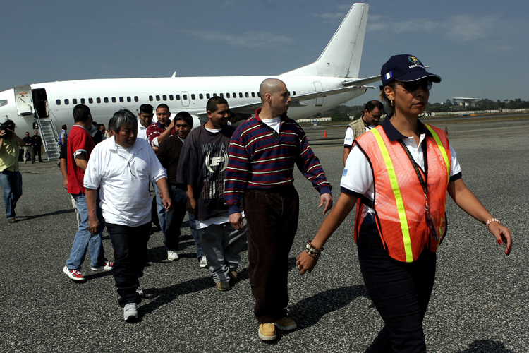 Guatemalans deported from the United States are escorted by an immigration official upon their arrival at La Aurora International Airport in Guatemala City. (AP/Moises Castillo)