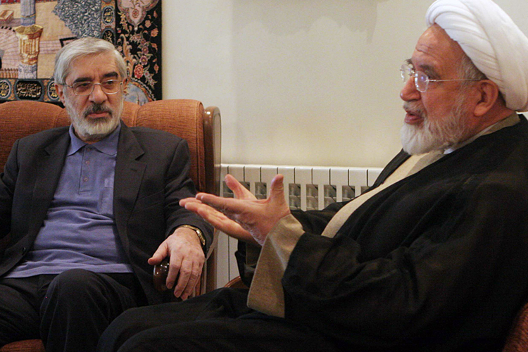 The now-confined leaders of Iranian opposition, Mahdi Karroubi, right, and Mir Hossein Mousavi, talk in freer days in Tehran. (AP)