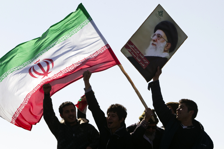 Demonstrators wave Iran's flag and hold up a picture of supreme leader Ayatollah Ali Khamenei during a ceremony to mark the 33rd anniversary of the Islamic Revolution, in Tehran's Azadi square February 11, 2012. (Raheb Homavandi / Reuters)