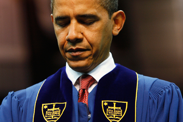 President Obama bows his head in prayer prior to speaking at the University of Notre Dame during commencement ceremonies in 2009. (AP)