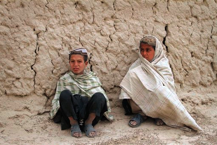 Afghan boys sit on the ground near the scene where Afghans were allegedly killed by a U.S. service member in Panjwai, Kandahar province south of Kabul, Afghanistan, Sunday, March. 11, 2012. (AP Photo/Allauddin Khan)
