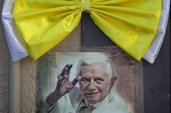 An image of Pope Benedict XVI is taped to a wall, topped with a Vatican-colored bow, in Leon, Mexico, Thursday March 22, 2012 (AP Photo/Eduardo Verdugo)