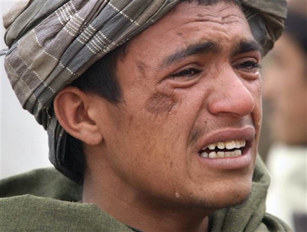 An Afghan youth mourns for relatives, who were allegedly killed by a U.S. service member in Panjwai, Kandahar province in Afghanistan, Sunday, March. 11, 2012 (AP Photo/Allauddin Khan)