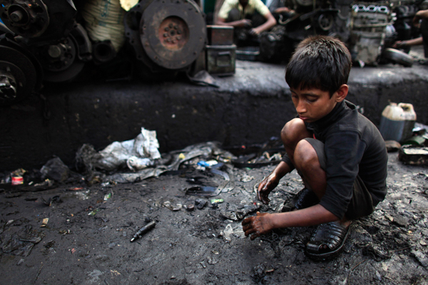 A boy collects scraps near a vehicle spare parts store in Dholaikhal, Dhaka February 29, 2012 (Reuters/Andrew Biraj)