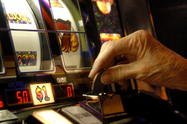 A player puts a dollar coin in an Atlantic City slot machine (AP)