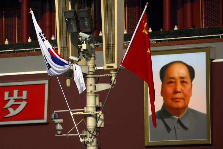 Security cameras on a pole in front of the giant portrait of former Chinese Chairman Mao Zedong at Beijing's Tiananmen Square Jan. 9, 2012. (David Gray / Reuters)