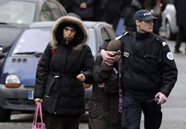 A student is flanked by an unidentified woman and a police officer as they leave a Jewish school after a gunman opened fire in Toulouse, southwestern France, Monday, March 19, 2012 (AP Photo/Manu Blondeau)
