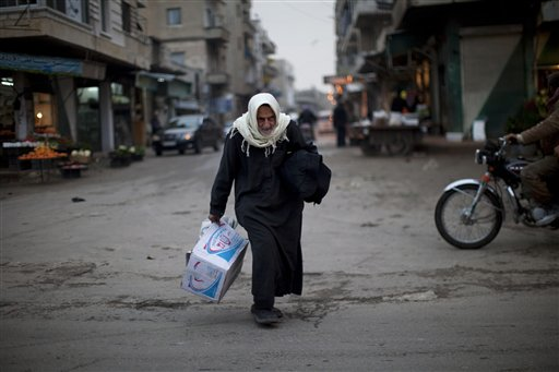A woman walks in a street market downtown of Idlib, north Syria, Wednesday, March 7, 2012. (AP Photo/Rodrigo Abd)