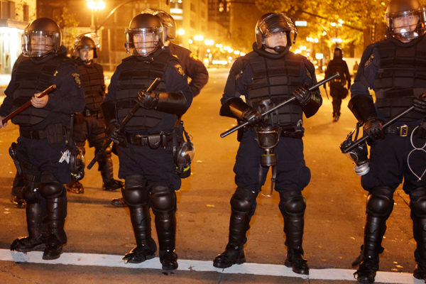 A line of police stand staged at an Occupy Oakland encampment in Oakland, Calif., early Monday, Nov. 14, 2011 (AP/Paul Sakuma)