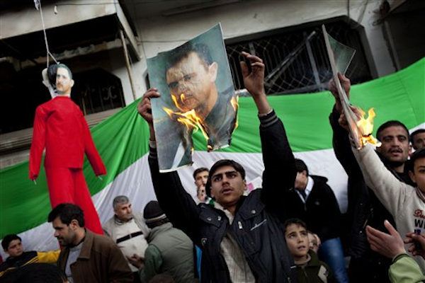 Protesters burn portraits of Syrian President Bashar al-Assad in northern Syria on Feb. 26, 2012 (AP Photo/Rodrigo Abd)