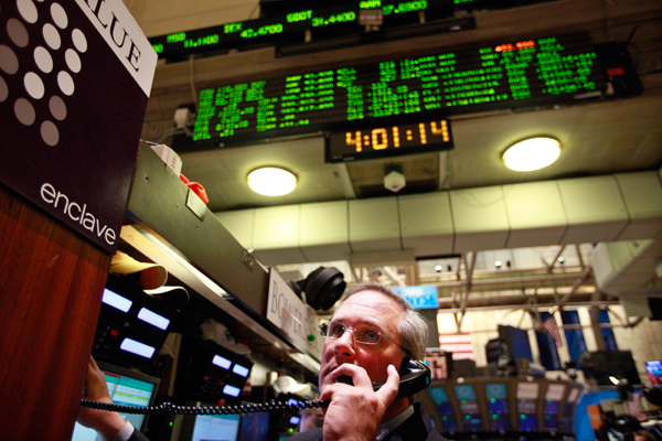 A trader looks up at the board just after the closing bell on the floor of the New York Stock Exchange, February 27, 2012. (Reuters/Brendan McDermid)