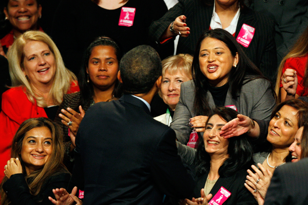 President Obama greets women onstage in November 2009. (AP/Mel Evans)