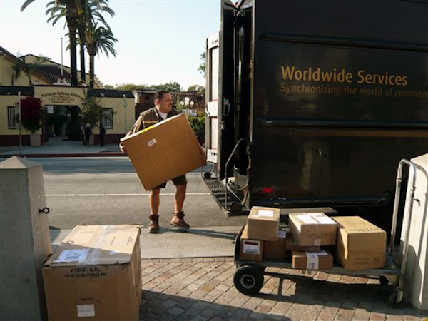 In this March 6, 2012 photo, a UPS worker loads packages in Los Angeles (AP Photo/Damian Dovarganes)