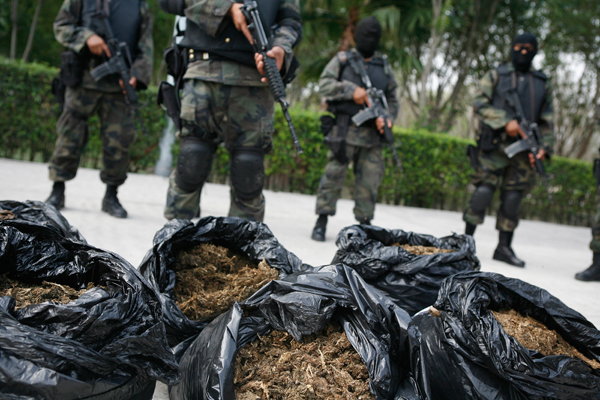 Soldiers stand guard next to bags of marijuana being displayed to the media at a military base on the outskirts of Monterrey, Mexico. (Reuters/Tomas Bravo)
