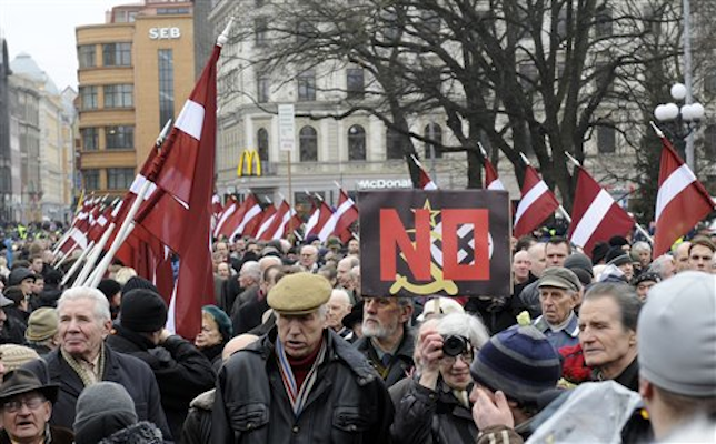 With Latvian flags, people march in a procession to honor soldiers who fought in a Waffen SS unit during World War II, in Riga, Latvia, Tuesday, March 16, 2012 (AP Photo/Roman Koksarov)