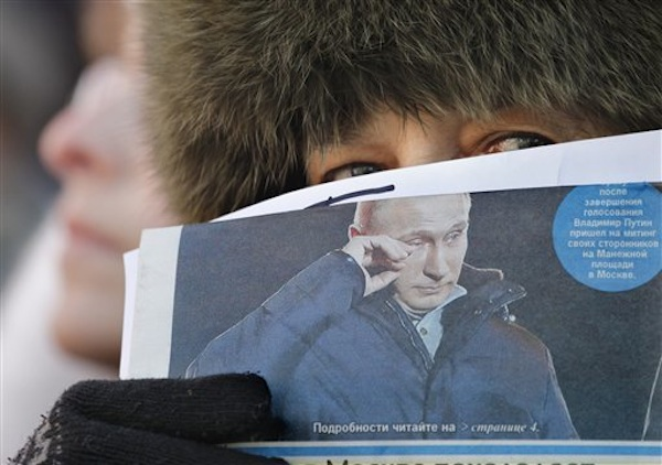 A protester holds a newspaper showing president-elect Vladmir Putin during an opposition rally in Moscow, Russia, Saturday, March 10, 2012 (AP Photo/Ivan Sekretarev)