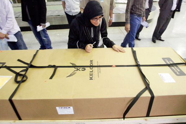 Fatima Alhimidi weeps over her mother Shaima Alawadi's coffin as it arrives in Najaf, Iraq. (AP/Alaa al-Marjani)