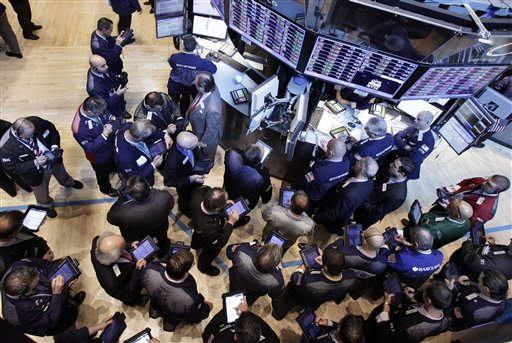 Traders gather at the post that handles Global Payments Inc. on the floor of the New York Stock Exchange (AP/Richard Drew)
