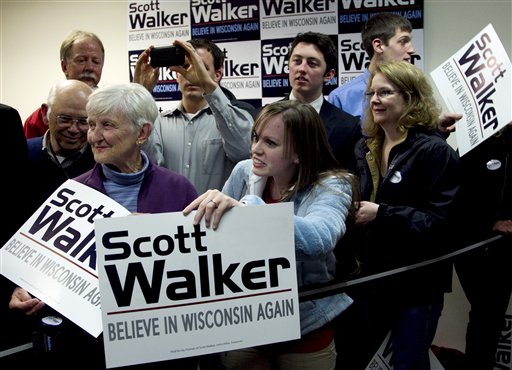 Supporters of Wisconsin Republican Gov. Scott Walker display placards during a visit by Republican presidential candidate, former Massachusetts Gov. Mitt Romney, not shown, during a campaign stop in Fitchburg, Wis., Saturday, March 31, 2012.  The phone bank is used in support of Walker who is facing a recall election in June 2012. (AP Photo/Steven Senne) (AP)