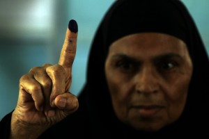 An Egyptian woman shows the ink on her finger after voting in an historic presidential election Wednesday, May 23, 2012, outside a polling station in Cairo, Egypt. (AP Photo/Hasan Jamali)