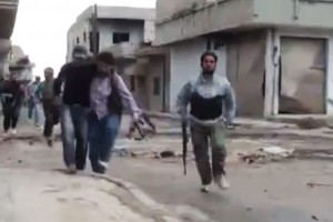 This image, made from amateur video released by the Shaam News Network and accessed Monday, May 14, 2012, purports to show a Syrian rebel helping an injured man in Rastan, Homs, Syria. (AP Photo/Shaam News Network via AP video)