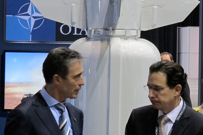 NATO Secretary General Anders Fogh Rasmussen speaks with a defense-industry official at the Chicago summit. (Alexander Zaitchik)