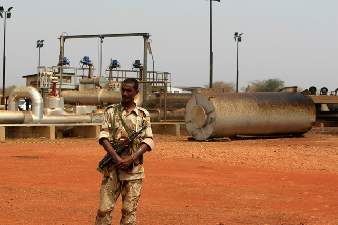 A member of the military stands guard near pump stations before a
ceremony in which oil operations at Heglig oilfield will resume in
Heglig, Sudan, May 2, 2012. (Reuters/Mohamed Nureldin Abdallah)
