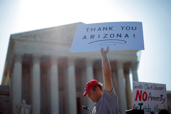 A supporter of Arizona's "show me your papers" immigration law demonstrates in front of the Supreme Court. (AP/Charles Dharapak)