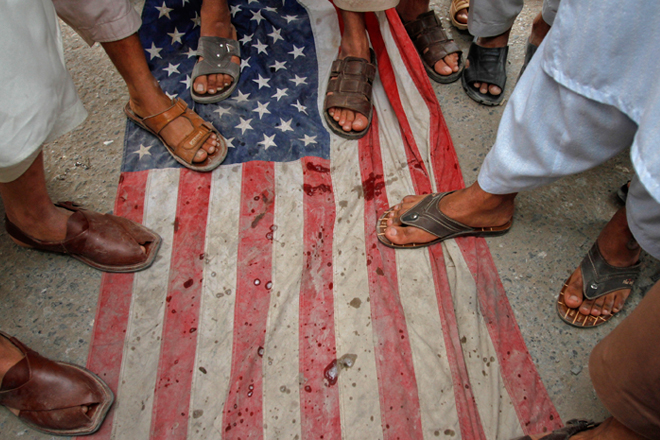 Pakistani men step on a U.S flag during an anti-American rally in Peshawar on April 13. (Reuters/Fayaz Aziz)