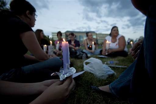 A group of friends with various connections to the deceased and wounded gather at a prayer vigil  outside the Aurora Municipal Center in Aurora, Colo.,(AP/Barry Gutierrez) (Associated Press)