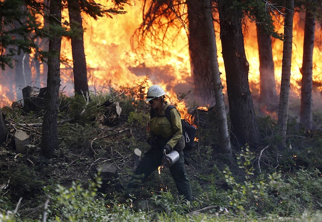 A firefighter works a burnout operation on the north flank of the Fontenelle Fire outside Big Piney, Wyoming, July 4, 2012. (Reuters/Jim Urquhart)