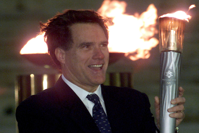 President of the organizing committee for the Salt Lake City Winter Olympic Games, Mitt Romney smiles as he raises an Olympic torch on December 3, 2001, during a handing-over ceremony in Athens' Panathenean stadium. (REUTERS/Yorgos Karahalis)