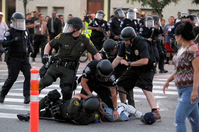 A protester is arrested by police officers as protesters try to occupy the intersection of Anaheim Blvd. and Broadway to demonstrate against recent police shooting in Anaheim, Calif. (Reuters/Alex Gallardo)