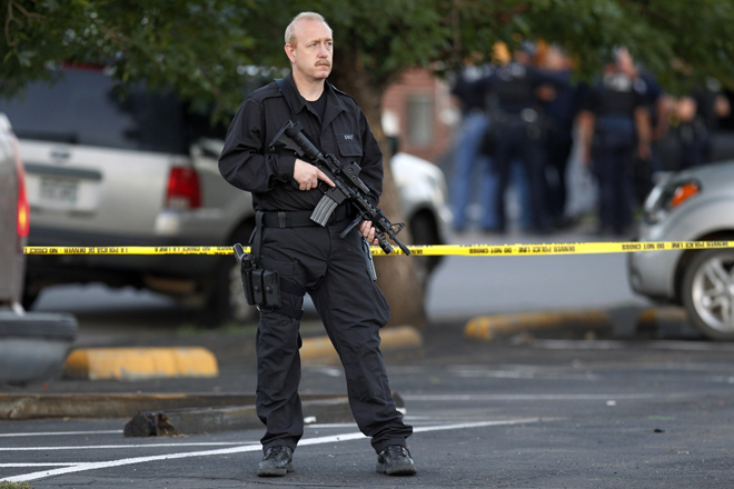 A SWAT team officer stands watch near an apartment house where the suspect in a shooting at a movie theater lived in Aurora, Colo., July 20, 2012. (AP/Ed Andrieski)