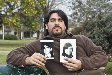 Guillermo Perez Roisinblit holds pictures of his biological parents. He's one of hundreds of victims of the Argentine military regime's baby abduction scheme. (Ed Stocker, GlobalPost)
