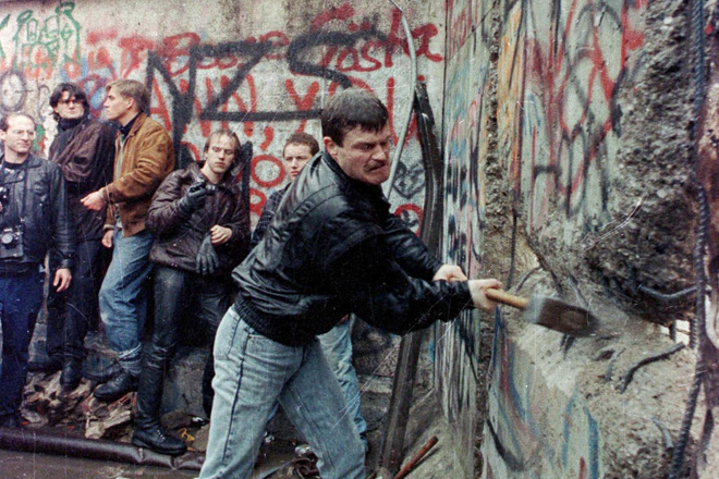 A demonstrator attacks the Berlin Wall with a sledgehammer in November 1989. (Reuters)
