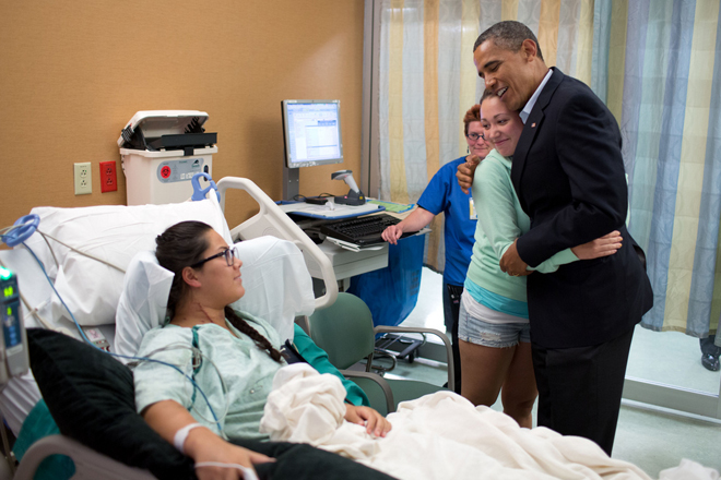 President Obama hugs Stephanie Davies, who helped keep her friend, Allie Young, left, alive after she was shot during the movie theater shootings in Aurora, Colo. (The White House/Pete Souza)
