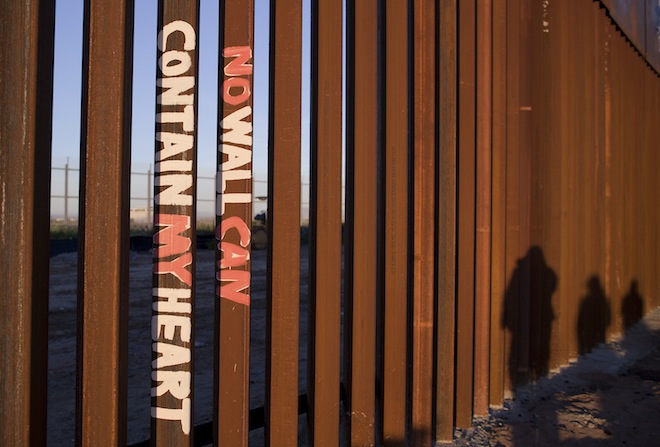 This Saturday, Jan. 28, 2012 photo shows graffiti reading "NO WALL CAN CONTAIN MY HEART" on the U.S. border fence in Tijuana, Mexico. (AP/Julie Jacobson)