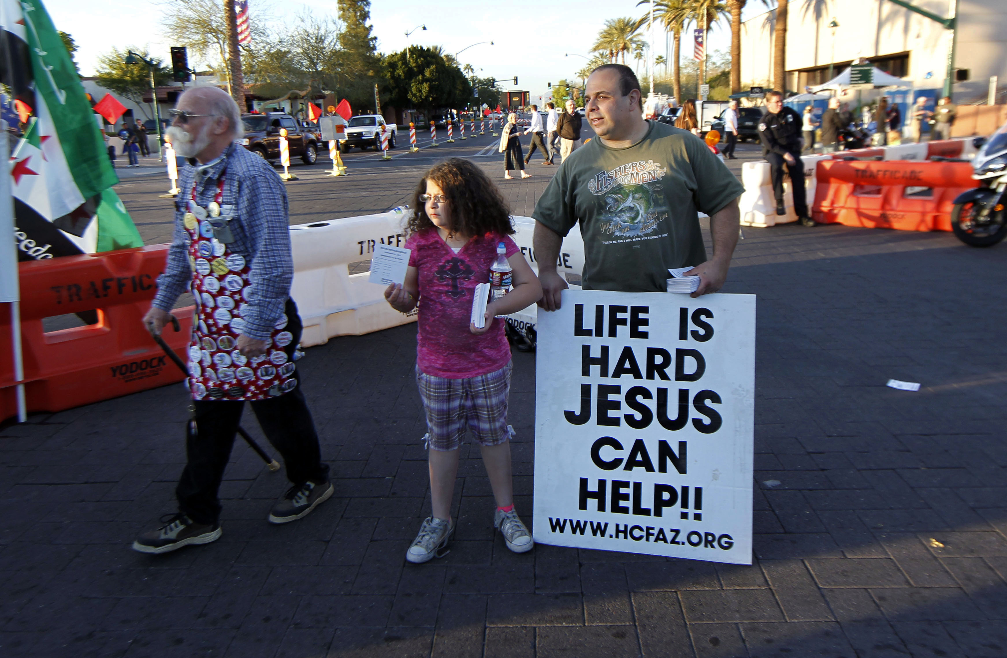 Michael Salman, right, and his daughter Abigail Salman, 8, both of Mesa, Ariz., hand out religious literature in Mesa, Ariz. (AP/Gerald Herbert)