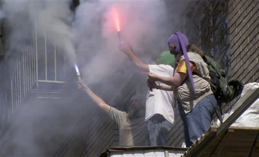 Three men in balaclava's light flares on the balcony of a building shouting: "Freedom to Pussy Riot!" (AP/APTN)