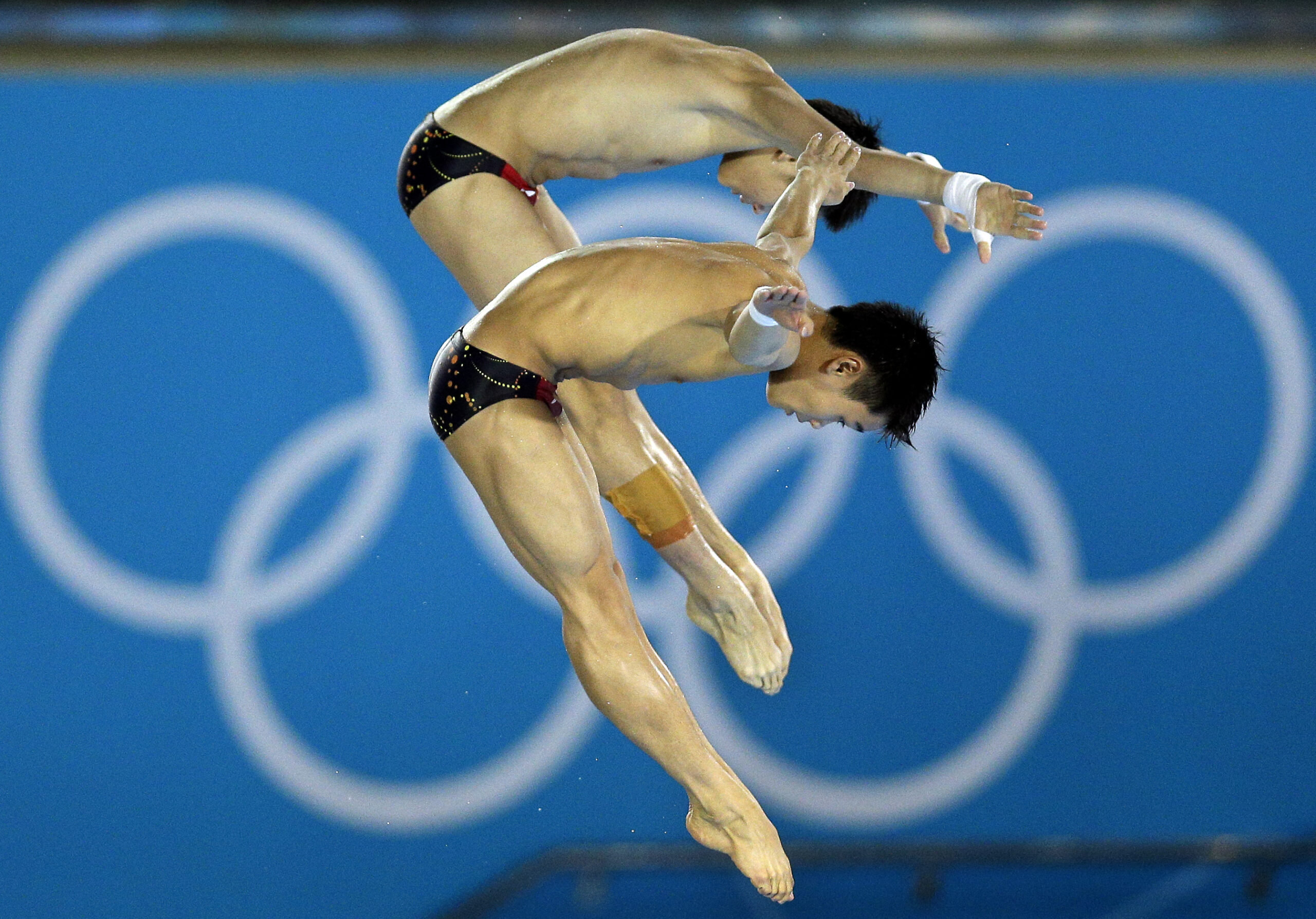 Gold medalists Cao Yuan and Yanquan Zhang from China compete during the Men's Synchronized 10 Meter Platform Diving final (AP/Michael Sohn)