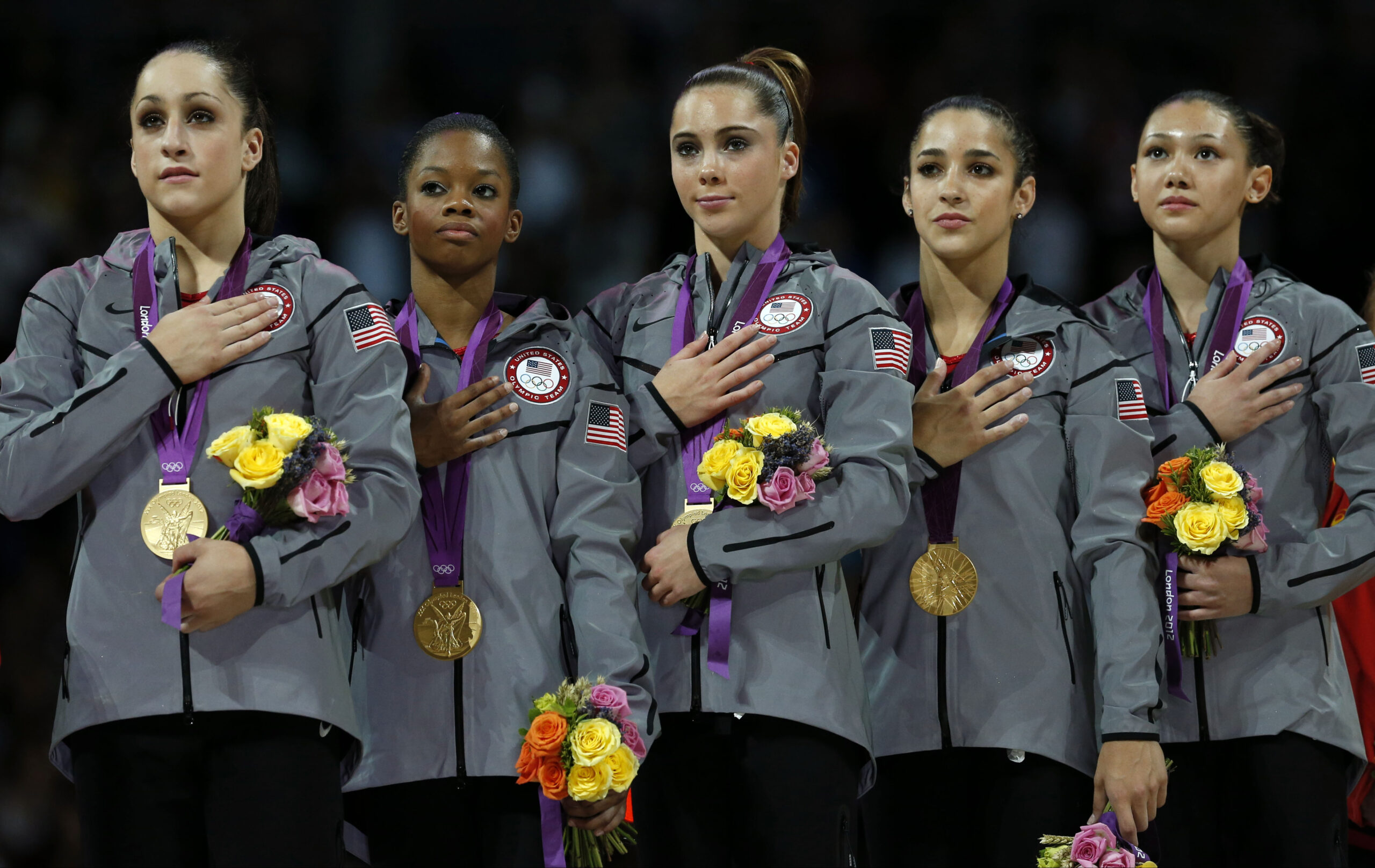 The gold-medal winning American gymnastics team listens to the U.S. national anthem (AP/Matt Dunham)