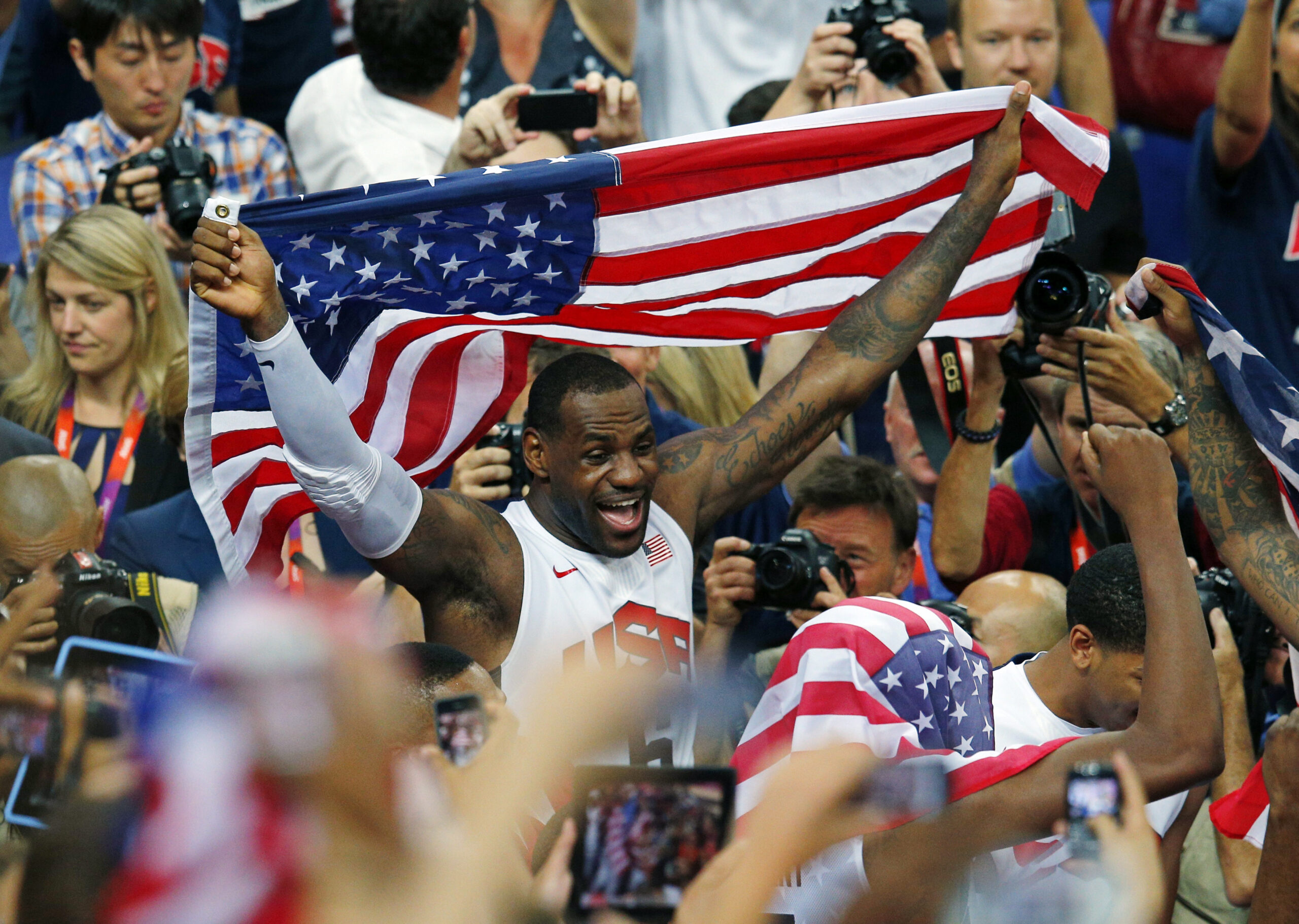 LeBron James of the U.S. celebrates with the flag after a victory against Spain in the men's gold medal basketball game (Reuters/Brian Snyder)