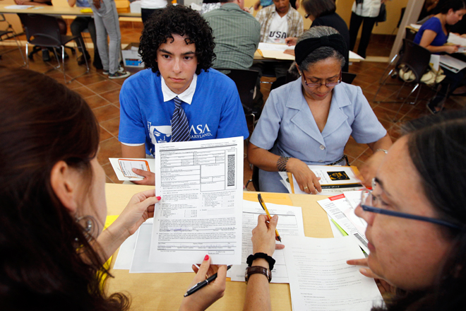 Colombian immigrants Daniel Nino, left, and his mother Patricia Cara get help filling Deferred Action Childhood Arrivals applications in Langley Park, Md. (AP/Jose Luis Magana)
