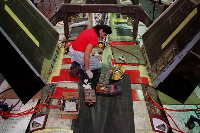An assembly line worker installs parts on a jet at the Northrop plant in Los Angeles (AP)