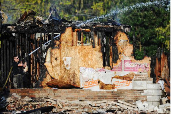 A Carl Junction, Mo., firefighter works to extinguish the smoldering remains of the Islamic Society of Joplin mosque, Monday, Aug. 6, 2012, in Joplin, Mo. (AP/The Joplin Globe/T. Rob Brown)
