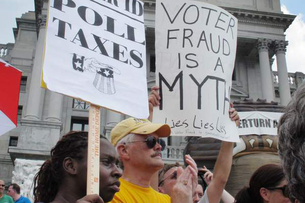 Demonstrators hold signs on the steps of the Pennsylvania Capitol to protest the state's new voter identification law. (AP/Marc Levy)