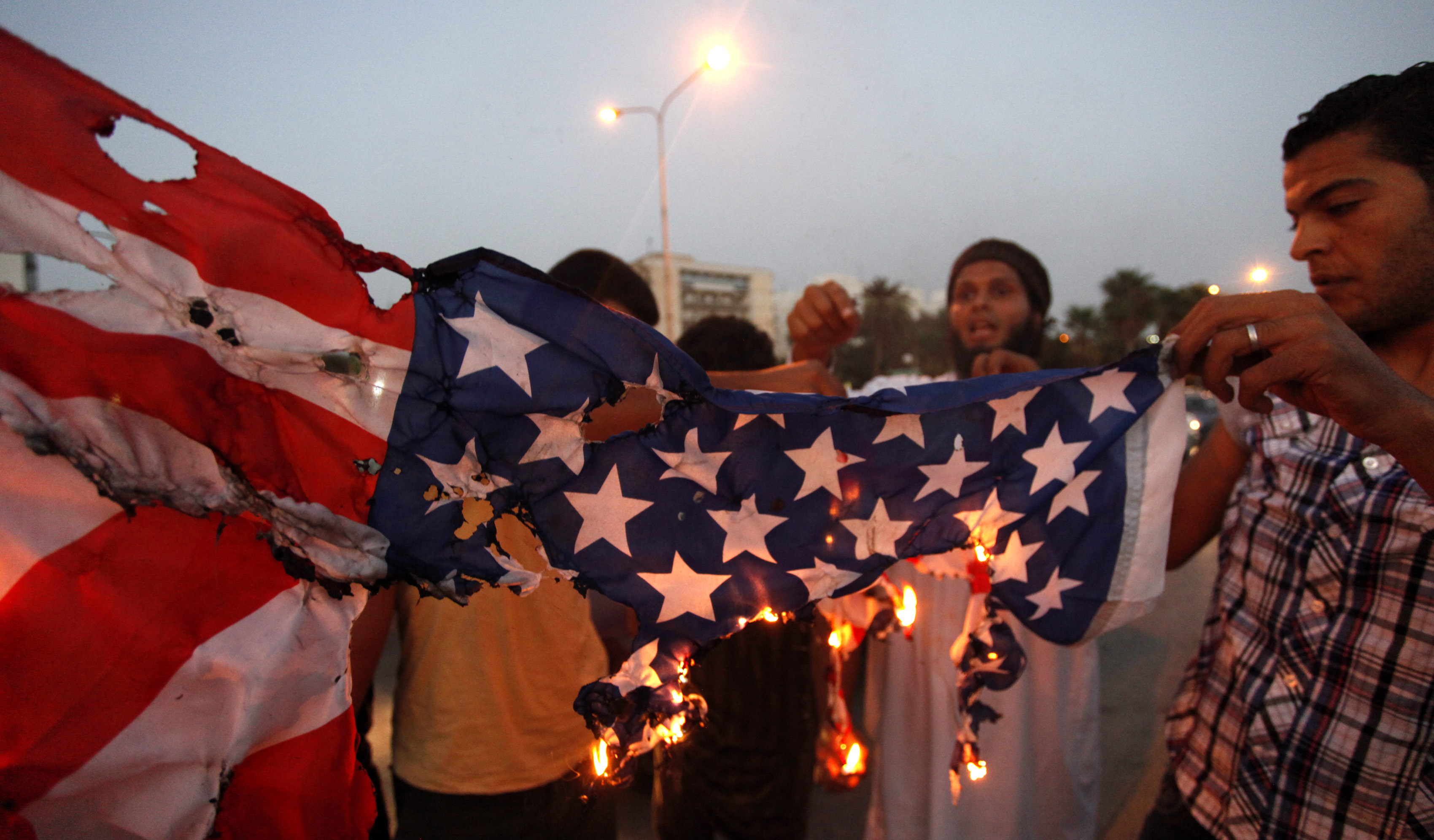Libyan followers of Ansar al-Shariah Brigades burn the U.S. flag during a protest in front of the Tibesti Hotel, in Benghazi, Libya (AP/ Mohammad Hannon)